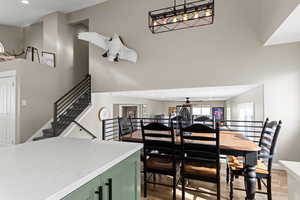 Dining area featuring recessed lighting, light wood-style flooring, and a towering ceiling