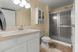 Bathroom featuring light tile patterned floors, vanity, and a stall shower