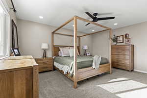 Carpeted bedroom with a ceiling fan and recessed lighting