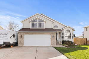 Traditional-style house with brick siding, concrete driveway, an attached garage, and a shingled roof
