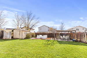 Fenced backyard with a storage unit, a patio, and a pergola