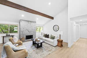 Living room with a fireplace, light wood finished floors, and recessed lighting