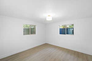 Unfurnished room featuring light wood-style floors and a textured ceiling