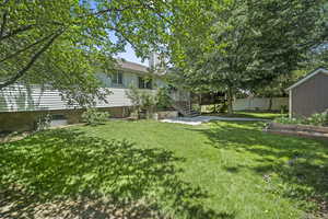 View of yard with a vegetable garden, a shed, stairs, and a deck