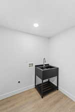 Washroom with light wood-type flooring, recessed lighting, washer hookup, and hookup for an electric dryer