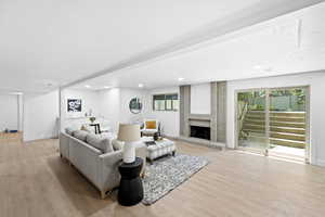 Living area with light wood-type flooring, a brick fireplace, recessed lighting, and a textured ceiling