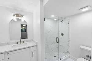 Bathroom featuring vanity and a marble finish shower