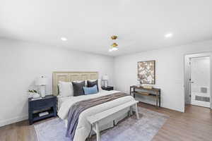 Bedroom with light wood-style flooring, a ceiling fan, and recessed lighting