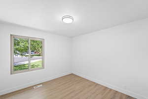 Spare room with light wood-style flooring and baseboards