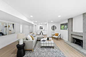 Living room featuring wood finished floors, a fireplace, and recessed lighting