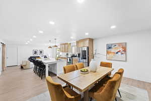 Dining area featuring recessed lighting, light wood-type flooring, and a barn door