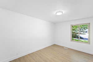 Unfurnished room with light wood-style flooring and a textured ceiling