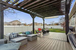 Wooden terrace with an outdoor living space, a pergola, a fenced backyard, and a residential view