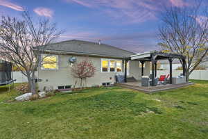 Rear view of property featuring a trampoline, stucco siding, a wooden deck, a pergola, and a tile roof