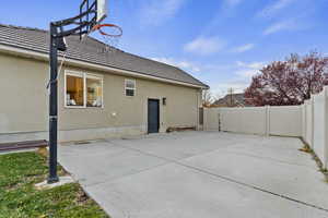 Rear view of property featuring a fenced backyard, stucco siding, and a tiled roof
