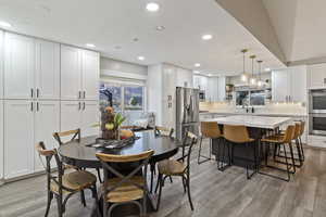 Dining area with light wood-type flooring, recessed lighting, and plenty of natural light