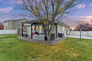 Back of house with a fenced backyard, stucco siding, a wooden deck, an outdoor hangout area, and a pergola