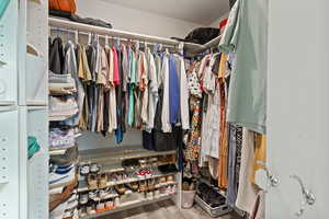 Walk in closet with light wood-style flooring