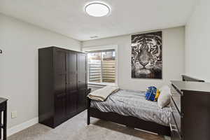 Bedroom with light carpet and a textured ceiling