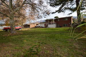 Back of property with a yard and a sunroom