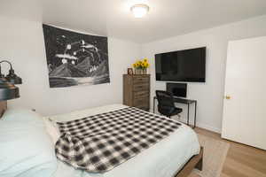 Bedroom with wood finished floors and baseboards