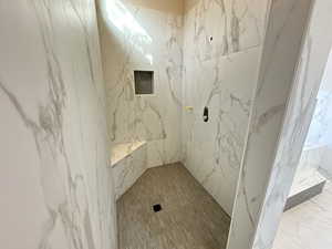 Bathroom featuring a marble finish shower and marble finish floors