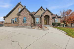 View of front of house featuring stucco siding, stone siding, and a garage