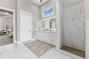 Full bathroom featuring light marble finish flooring, vanity, plenty of natural light, and a marble finish shower