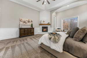 Carpeted bedroom featuring a large fireplace, ornamental molding, ceiling fan, and recessed lighting