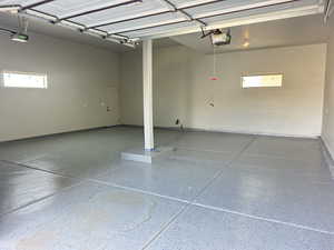 Garage featuring baseboards and a garage door opener