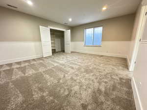 Unfurnished bedroom featuring wainscoting, a closet, recessed lighting, and carpet