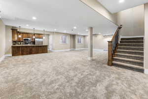 Unfurnished living room featuring recessed lighting, stairway, and light carpet