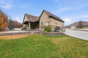 Rear view of property with a patio area, stucco siding, and brick siding