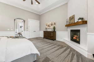 Bedroom with a fireplace, recessed lighting, arched walkways, light colored carpet, and a ceiling fan