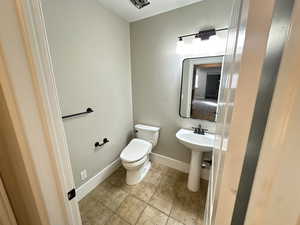 Bathroom with light tile patterned floors and a textured ceiling