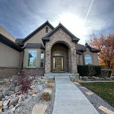 Doorway to property featuring stone siding, stucco siding, a standing seam roof, and a metal roof