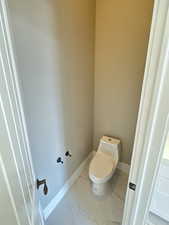 Bathroom featuring marble finish floors and baseboards
