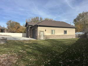 View of home's exterior featuring brick siding, stucco siding, an attached garage, and driveway