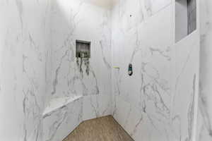 Full bath featuring a marble finish shower