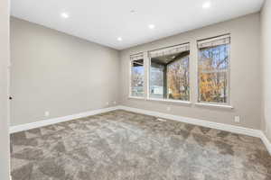 Carpeted spare room featuring baseboards and recessed lighting
