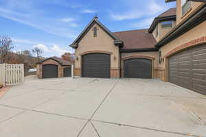 View of front facade featuring stucco siding, driveway, and brick siding