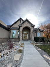 Entrance to property with stucco siding and stone siding