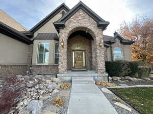 Property entrance featuring stone siding and stucco siding
