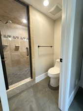 Bathroom with a shower stall, tile patterned flooring, and recessed lighting