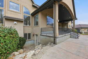 View of side of home with stucco siding and a patio