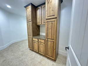 Interior space with dark stone counters, recessed lighting, and light tile patterned floors