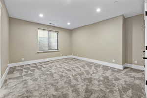 Empty room with recessed lighting and light carpet