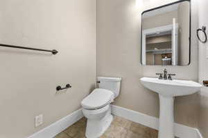 Half bathroom featuring toilet and baseboards