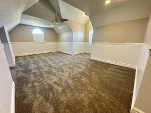 Additional living space featuring a wainscoted wall, vaulted ceiling, ceiling fan, carpet floors, and recessed lighting
