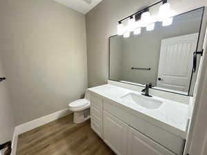 Half bathroom with vanity and dark wood finished floors